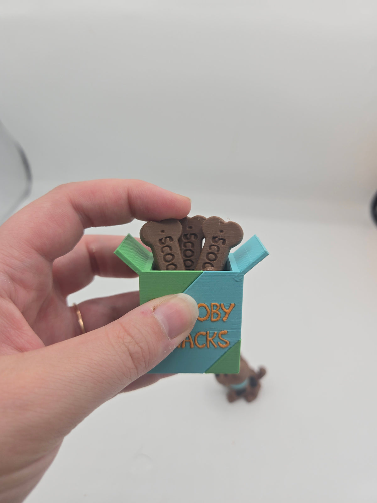 Scooby Snacks key clicker 3D print held in hand for size reference, dog-bone treats visible on top