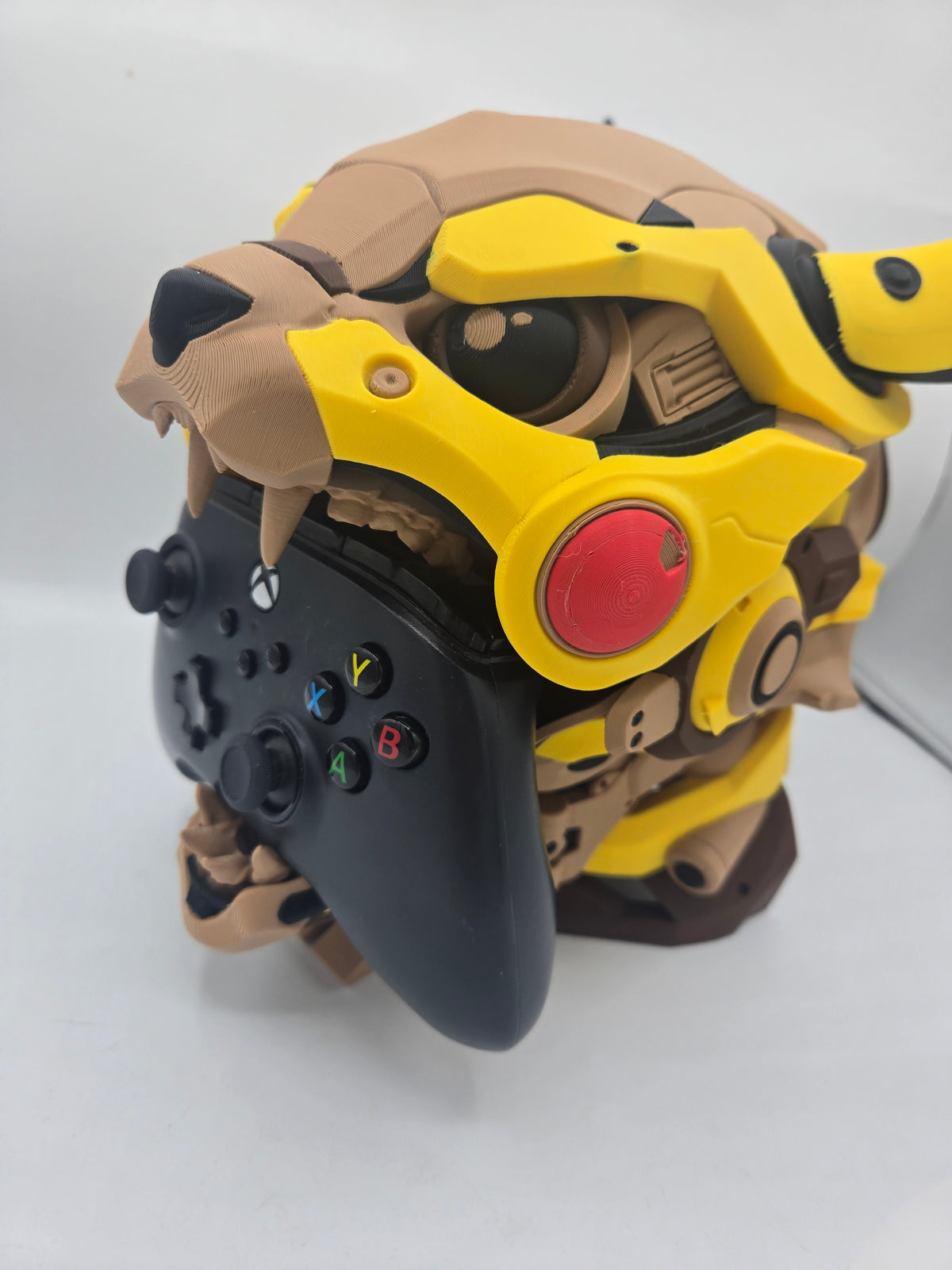 Mekachu Mecha Monster controller holder 3D print close-up three-quarter view with a black Xbox controller held in its open fanged jaw