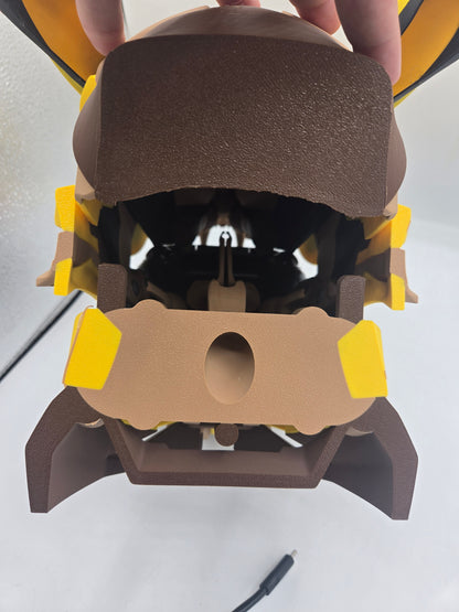 Mekachu Mecha Monster controller holder 3D print held from above showing the rear charging cord hole in the back panel and base legs, USB-C cable beside it
