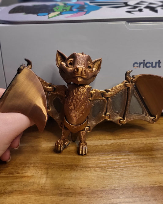 Poseable fruit bat figurine hanging from shelf display
