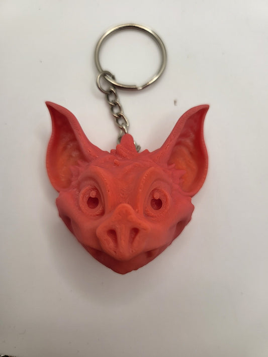 Bat fidget keychain shown on bag strap — palm-sized bat gift