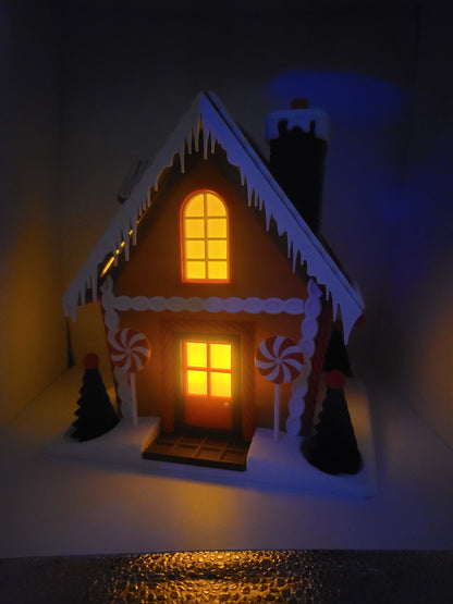 Holiday Gingerbread House Display in the dark — door and windows glowing warmly from tealights inside the 3D printed house