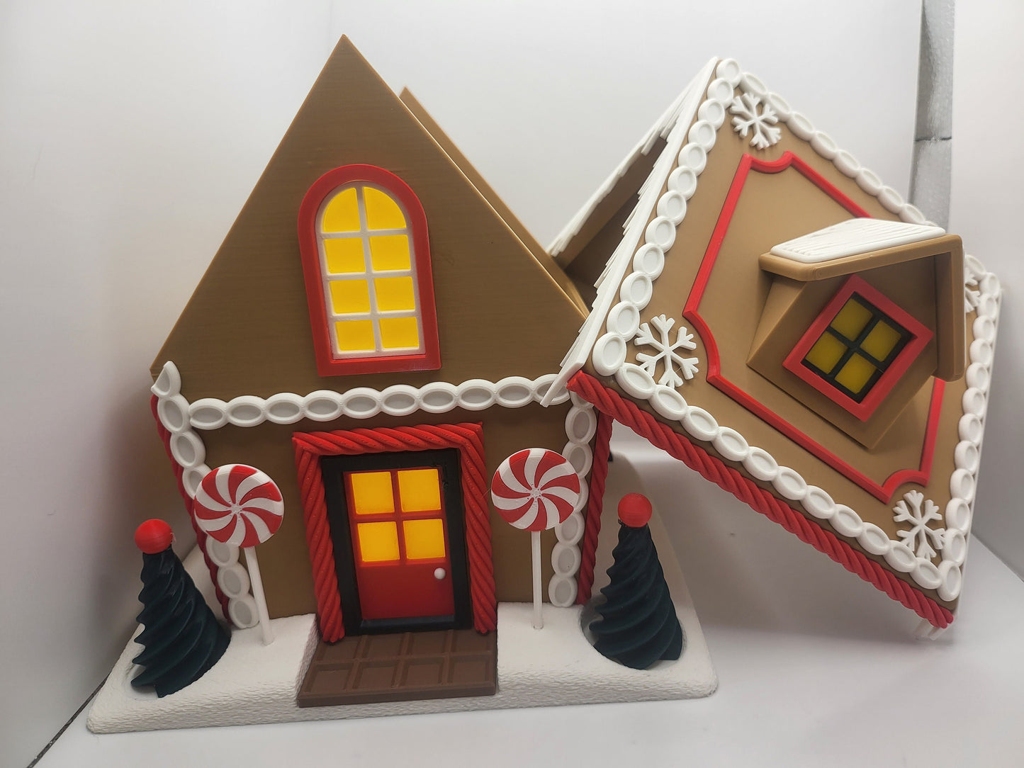 Holiday Gingerbread House Display disassembled — house front beside the removed icing-trimmed roof section, showing the liftable-roof design, 3D printed
