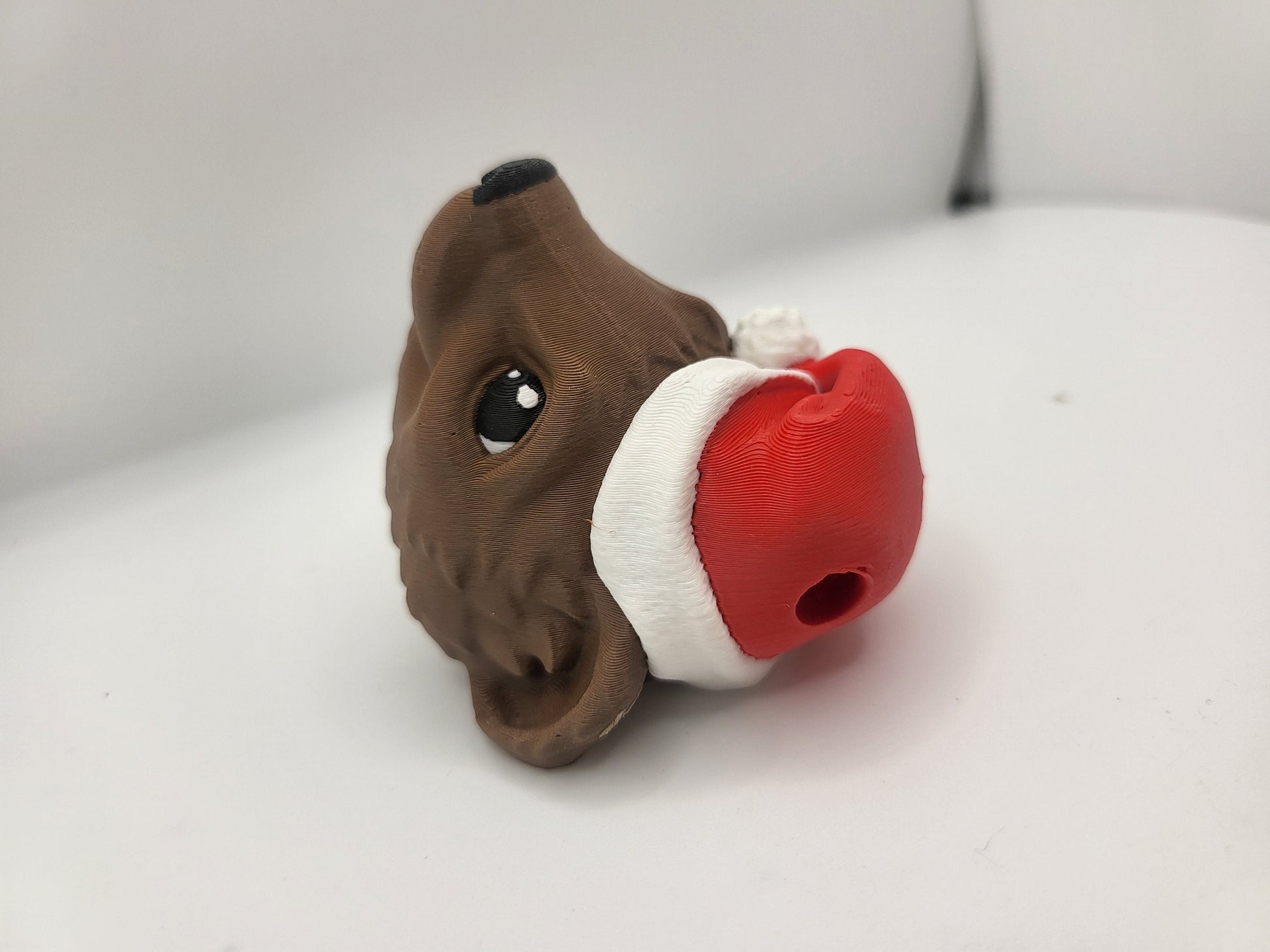Ferret with Santa Hat ornament side profile showing the hanging loop hole in the Santa hat for ornament string — 3D printed in brown filament