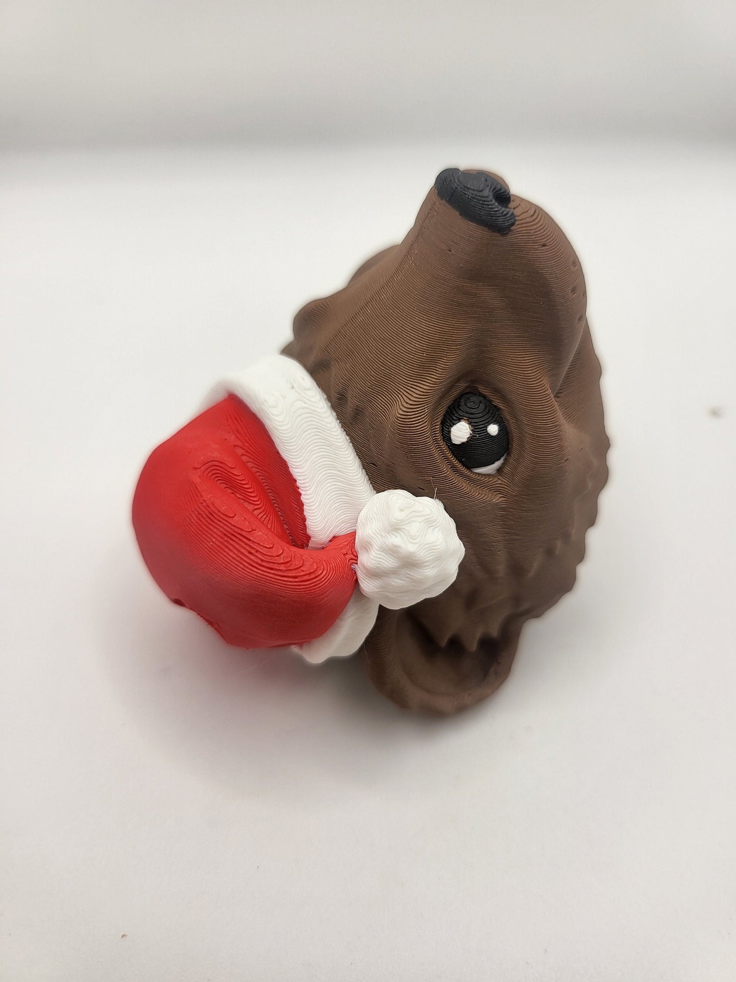 Ferret with Santa Hat ornament viewed from above — top-down angle showing the red hat, white pom, and brown textured fur, 3D printed