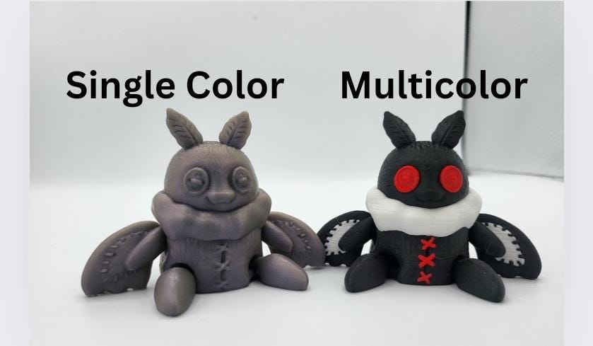 Plushie Mothman figurine on desk — chunky soft-look sculpt