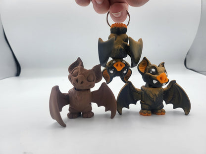 Mini bat fidget keychain held in hand showing palm-sized scale