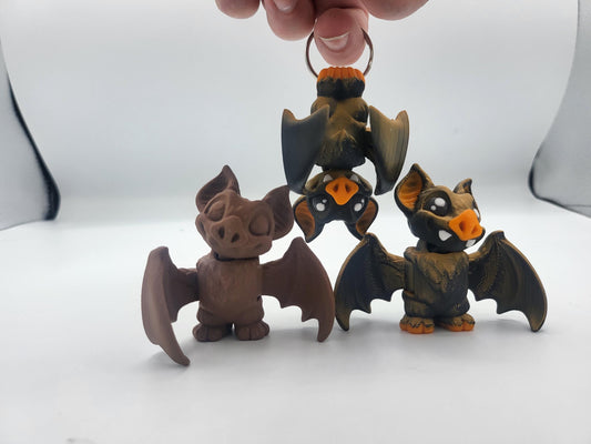 Mini bat fidget keychain held in hand showing palm-sized scale