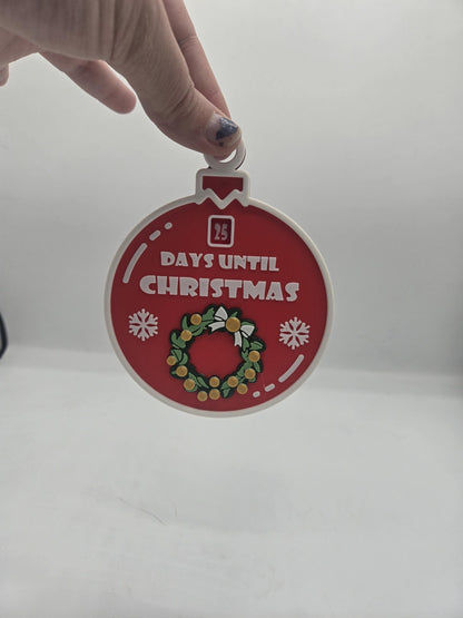 Christmas 25 Day Countdown ornament held by its hanging loop, showing the number window set to 25 — 3D printed red bauble with green wreath