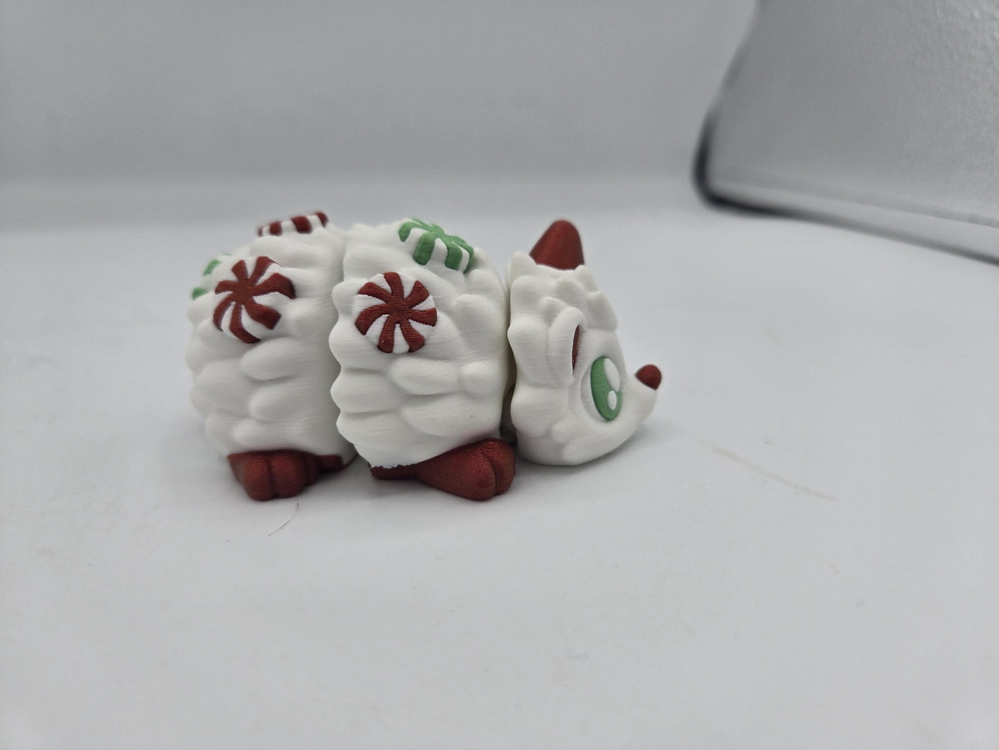 Peppermint Candies Christmas Hedgehog flexi, side view — articulated 3D printed segments decorated with red and green peppermint swirls