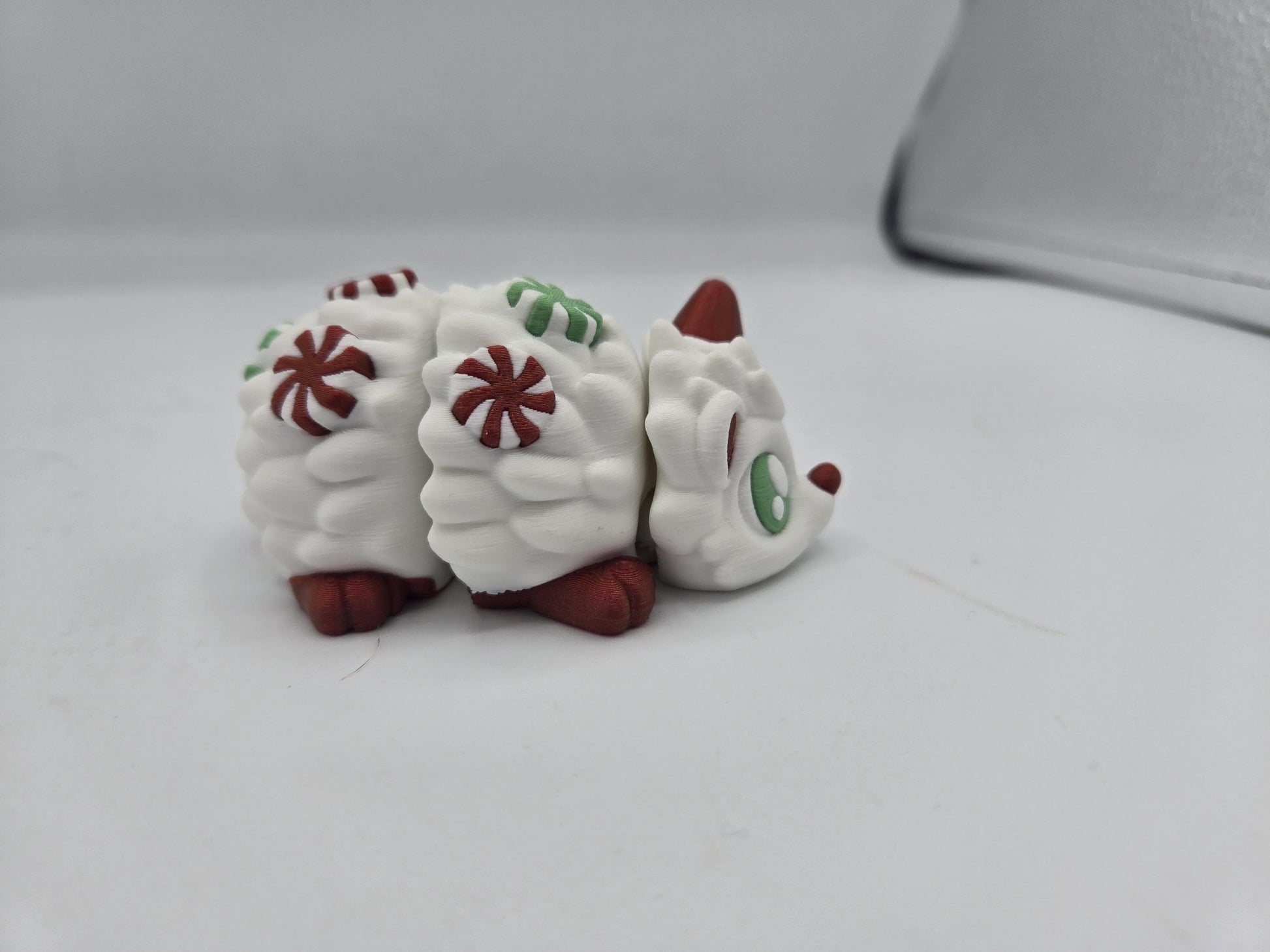 Peppermint Candies Christmas Hedgehog flexi, side view — articulated 3D printed segments decorated with red and green peppermint swirls
