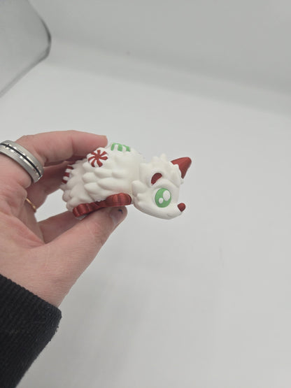 Peppermint Candies Christmas Hedgehog flexi held in hand — palm-sized 3D printed holiday fidget with Santa hat and candy details