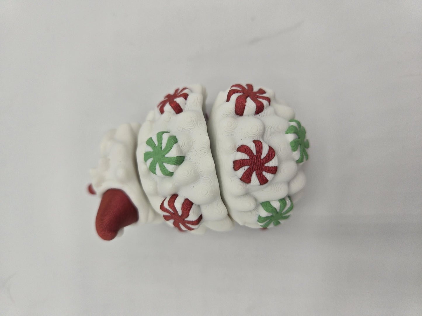Peppermint Candies Christmas Hedgehog flexi, top-down view — flexible body segments covered in red and green candy swirls, 3D printed