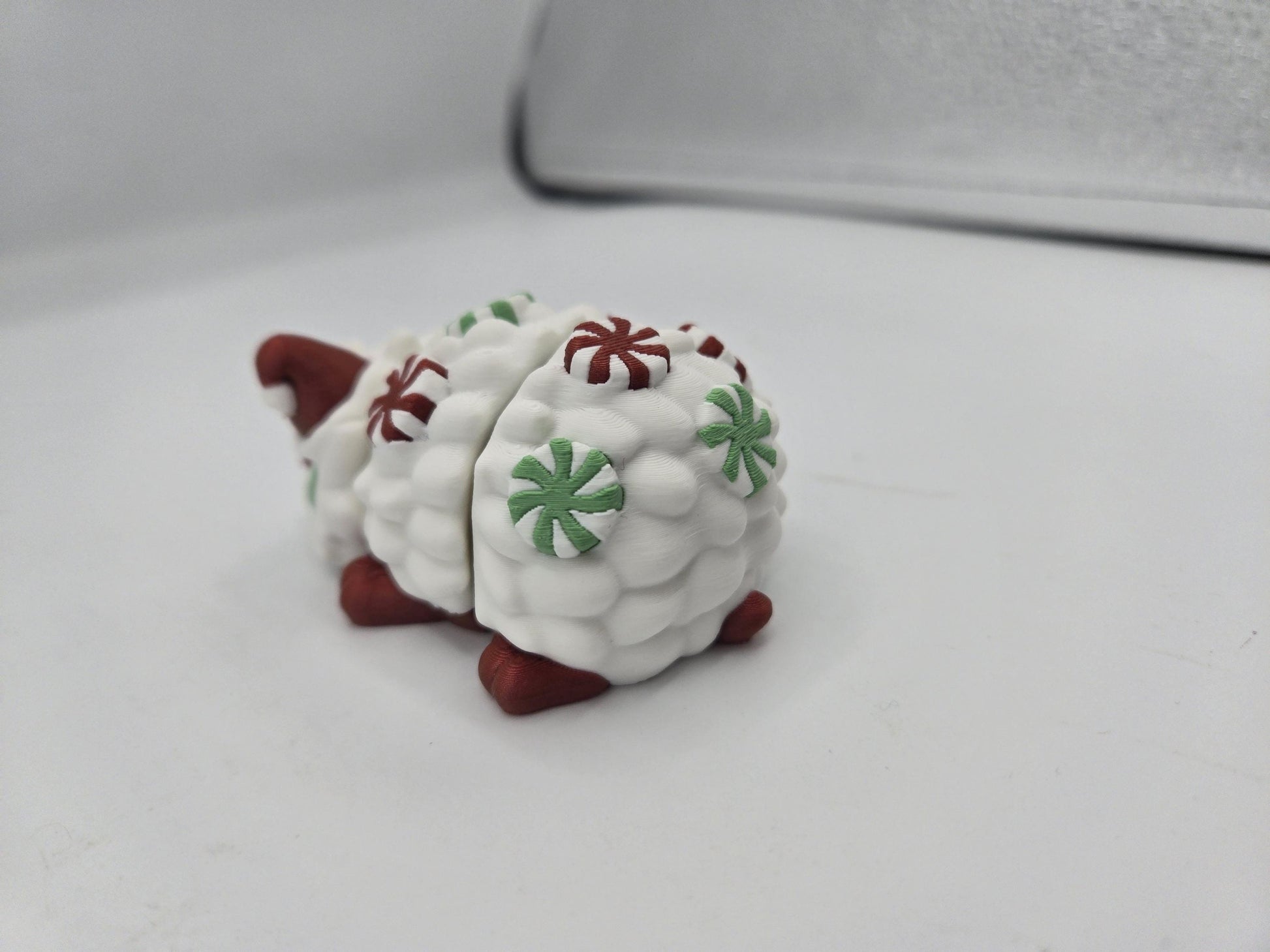 Peppermint Candies Christmas Hedgehog flexi, rear view — Santa hat peeking over mint-studded quills and red feet, 3D printed