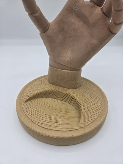Close-up of the wood-grain textured round base and wrist of the hand-shaped wine bottle holder