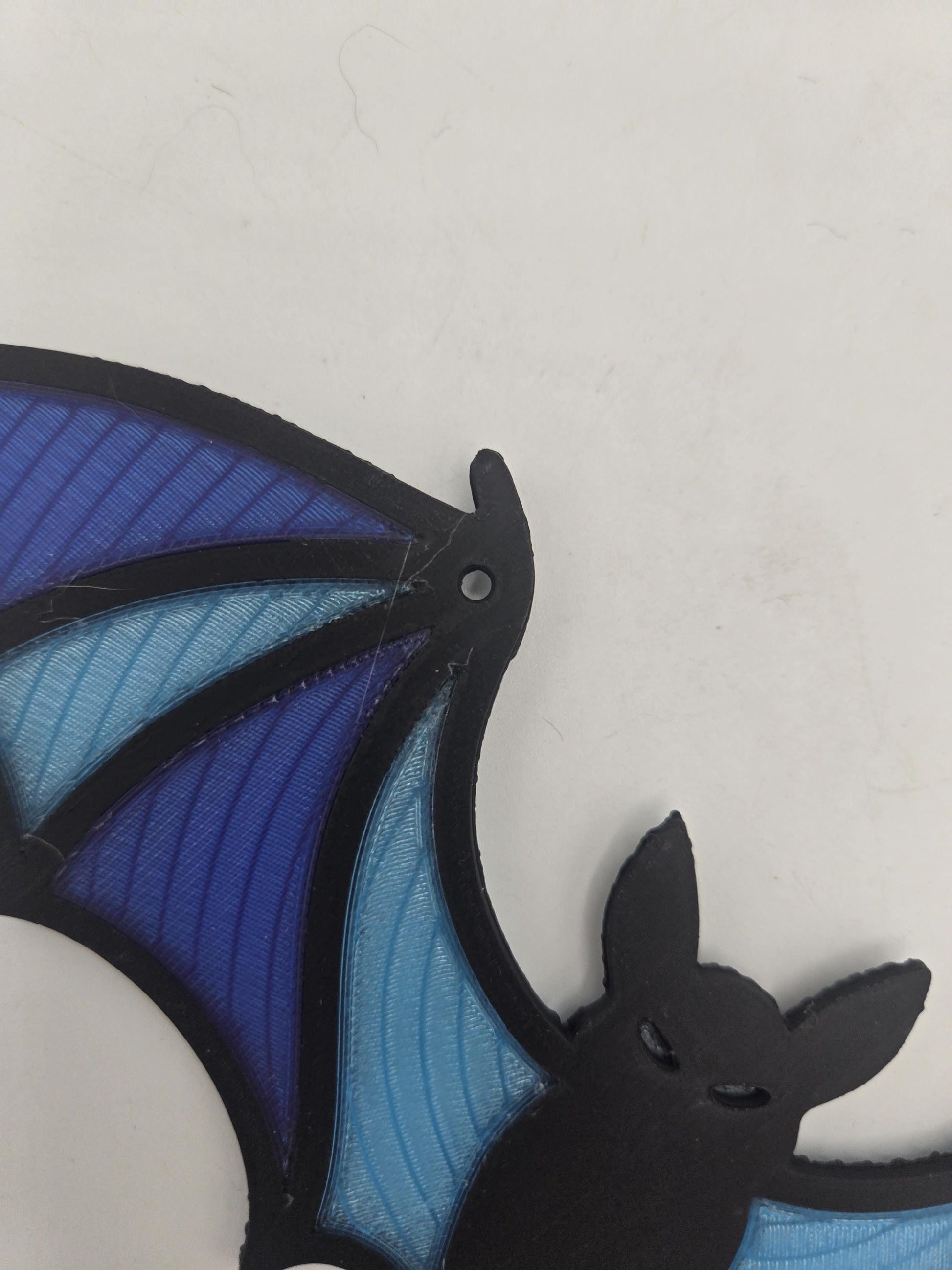 Close-up of the bat decor's face and built-in hanging hole at the top of the wing