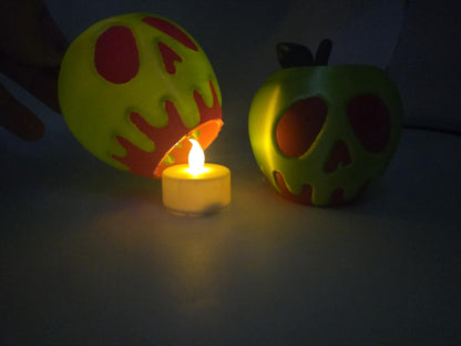 Poison apple display lifted to show the flickering LED tealight underneath glowing in the dark