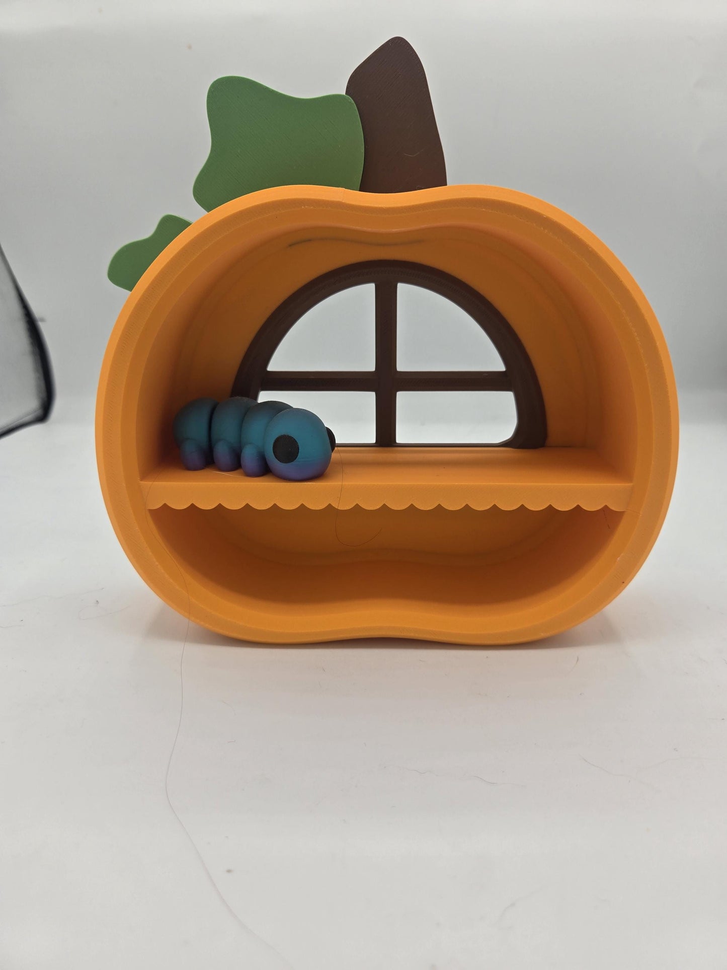 Pumpkin Trinket Shelf front view with a tiny blue caterpillar flexi displayed on the built-in shelf — 3D printed fall decor