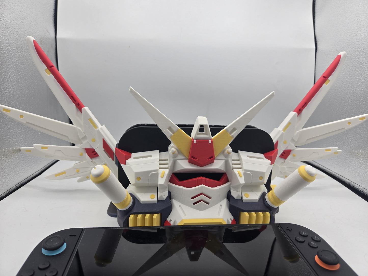 Mechdam Nintendo Switch 2 Dock Display, close front view — mecha head and shoulder wings above the console, 3D printed 90s mecha style