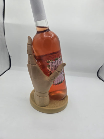 Back view of the sculpted hand cradling a full wine bottle upright on its round base