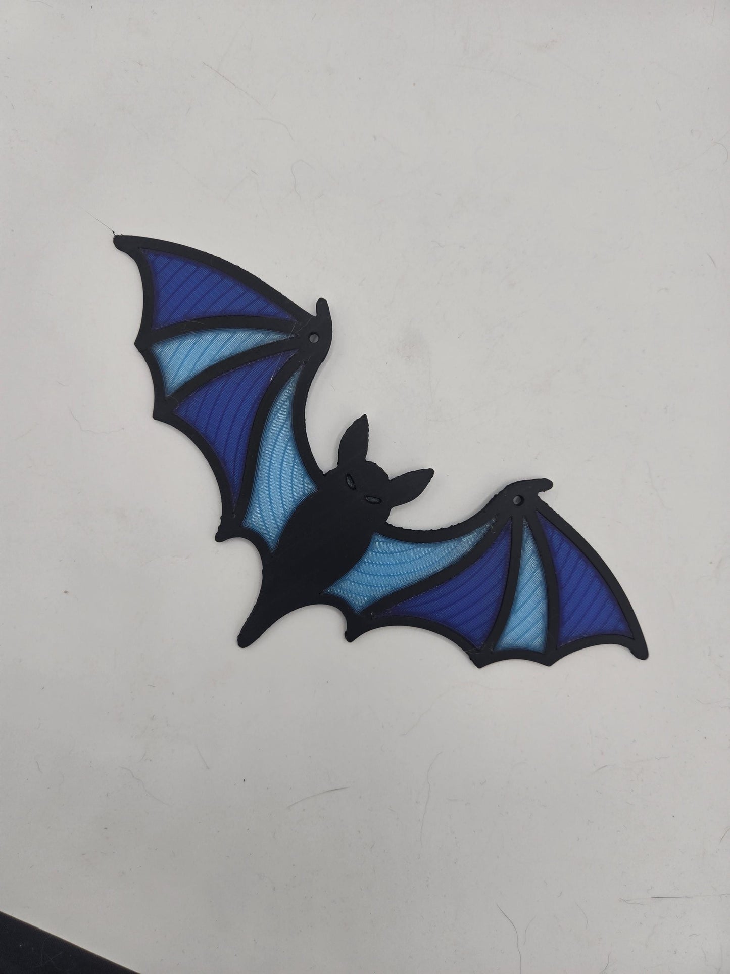 Spooky bat window hanging decor lying flat — bat silhouette with dark blue, royal blue, and light blue wing segments