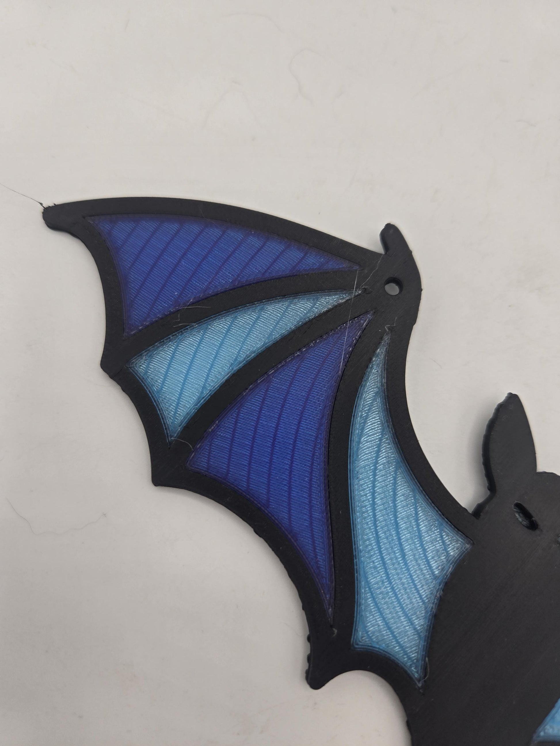 Detail of the translucent ribbed wing panels and hanging hole on the 3D printed bat suncatcher
