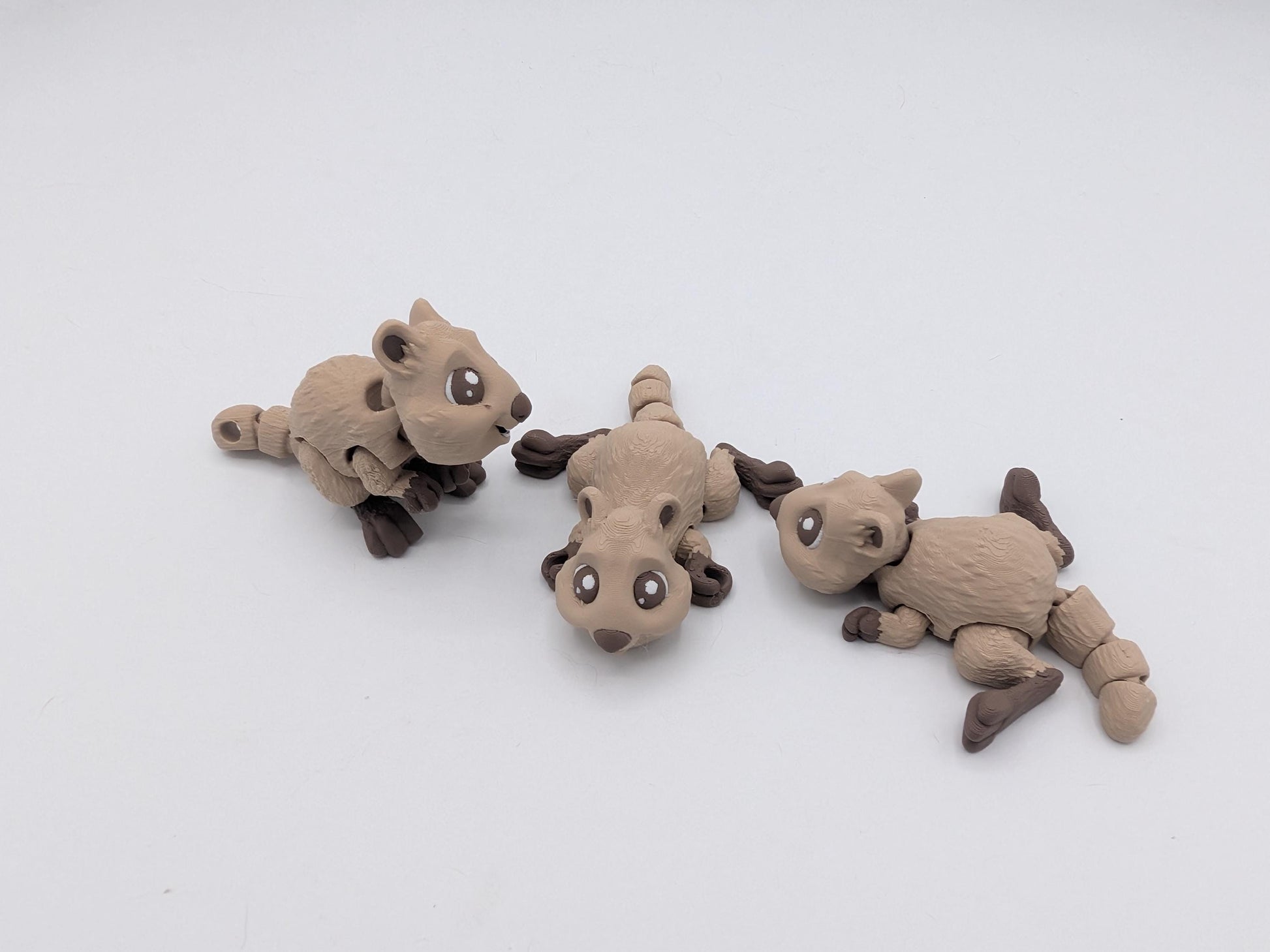 Mini quokka flexi trio in two-tone tan filament shown in sitting and lying poses