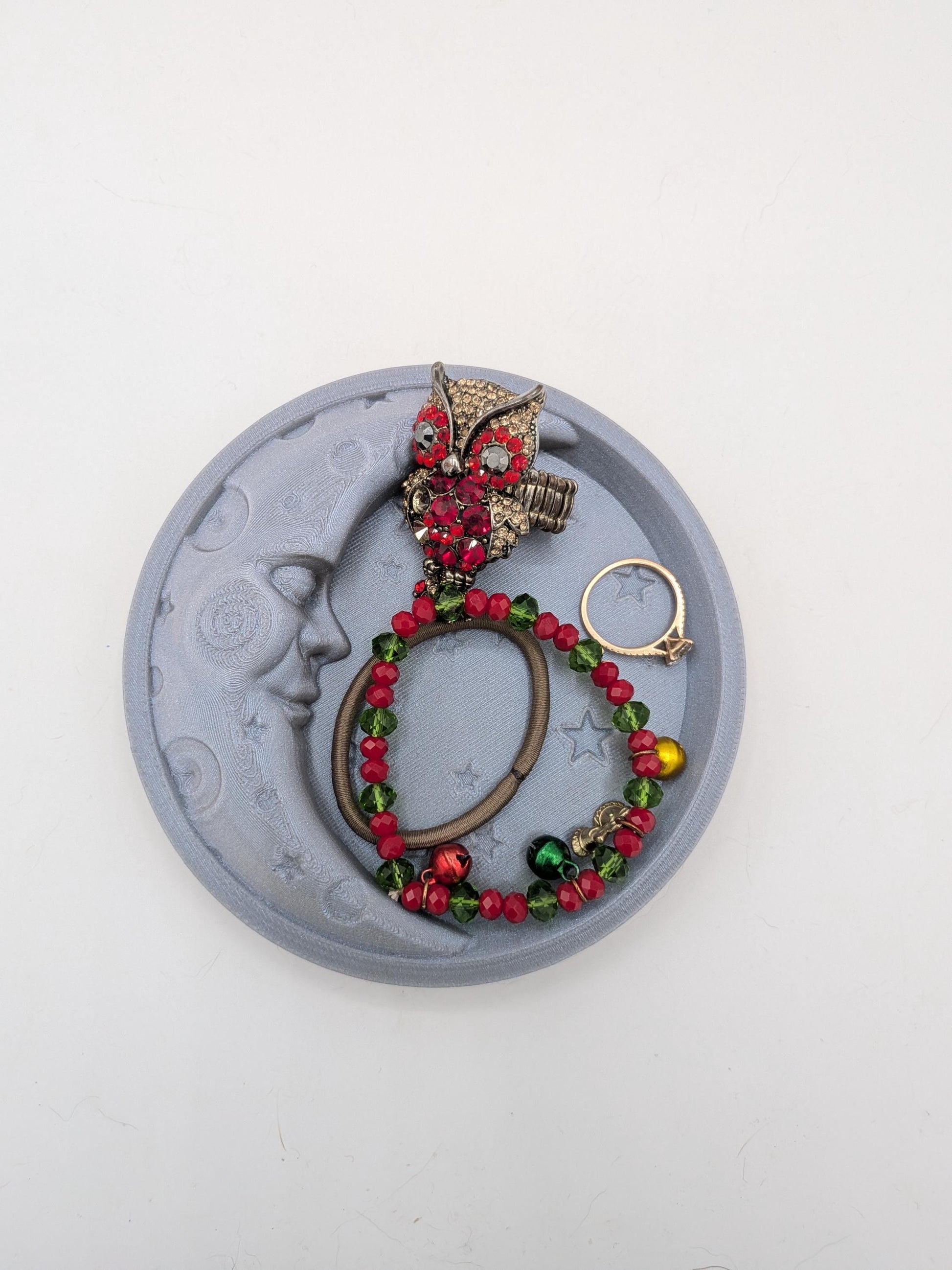 Straight-on top view of the moon and star trinket tray filled with rings, a bracelet, and small jewelry