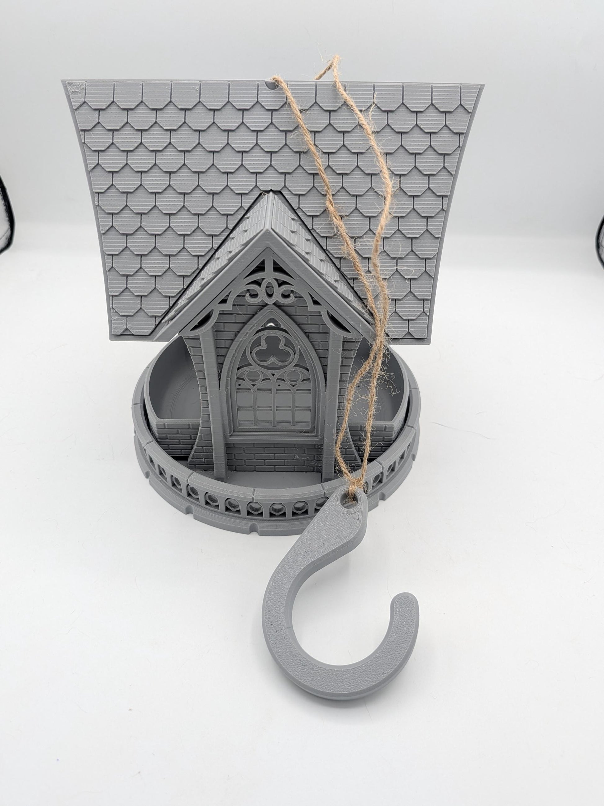 Gothic church bird feeder strung with twine and the included gray hanging hook