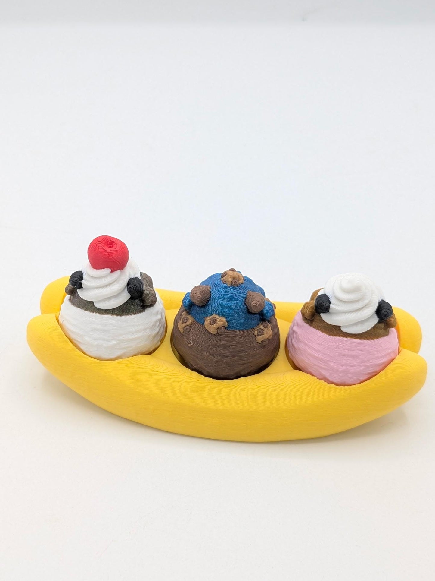 Single dragon banana split from behind — chocolate, vanilla, and strawberry scoops with cherry and whipped cream