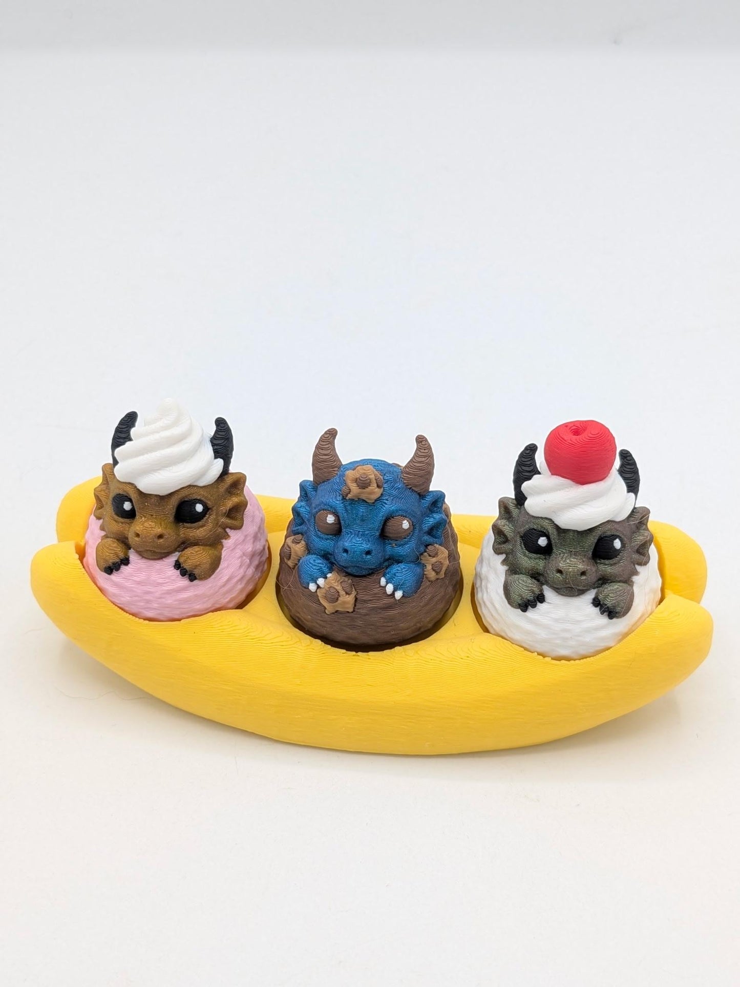Dragon banana split key clicker — strawberry, blueberry chocolate, and vanilla scoops each topped with a tiny dragon
