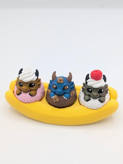 Dragon banana split key clicker — strawberry, blueberry chocolate, and vanilla scoops each topped with a tiny dragon