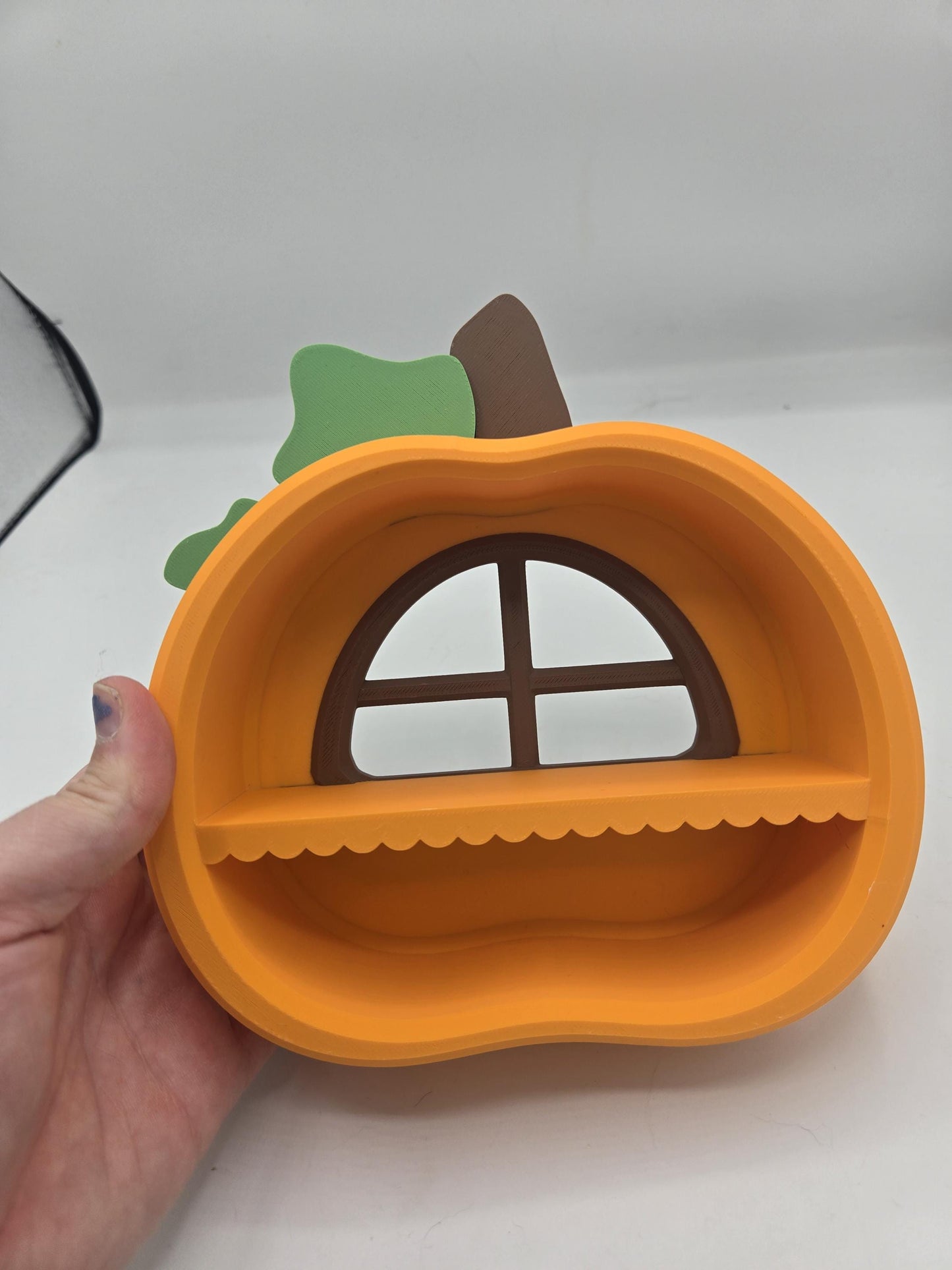 Pumpkin Trinket Shelf held in a hand for scale, showing the compact size of the 3D printed fall display shelf