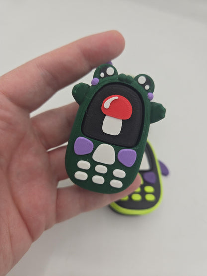 Kawaii frog phone clicker with mushroom screen held in hand — palm-sized 3D printed fidget with built-in mechanical key switch
