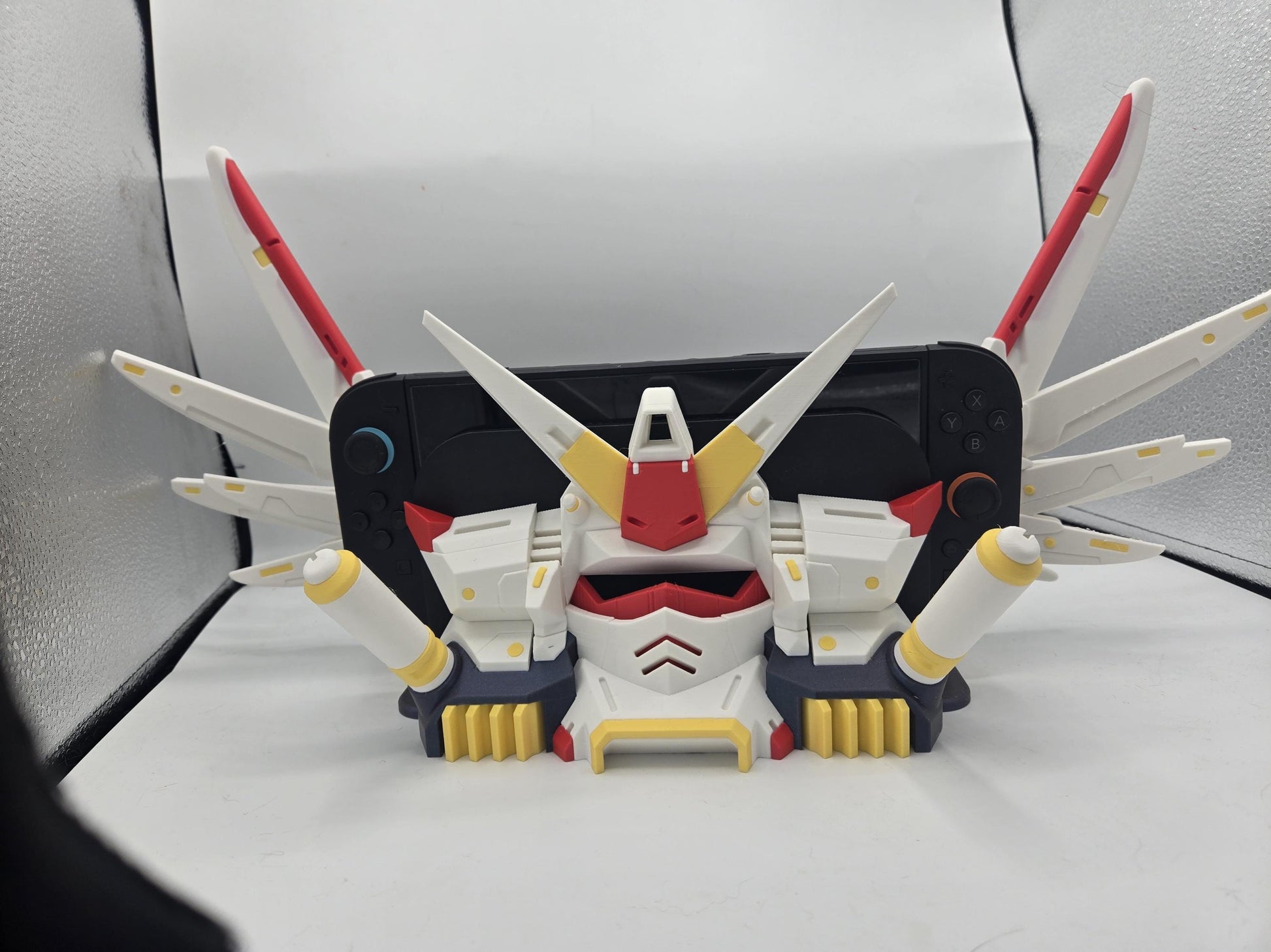 Mechdam Nintendo Switch 2 Dock Display, front view — console docked with wing blades spread wide and booster arms at the sides, 3D printed
