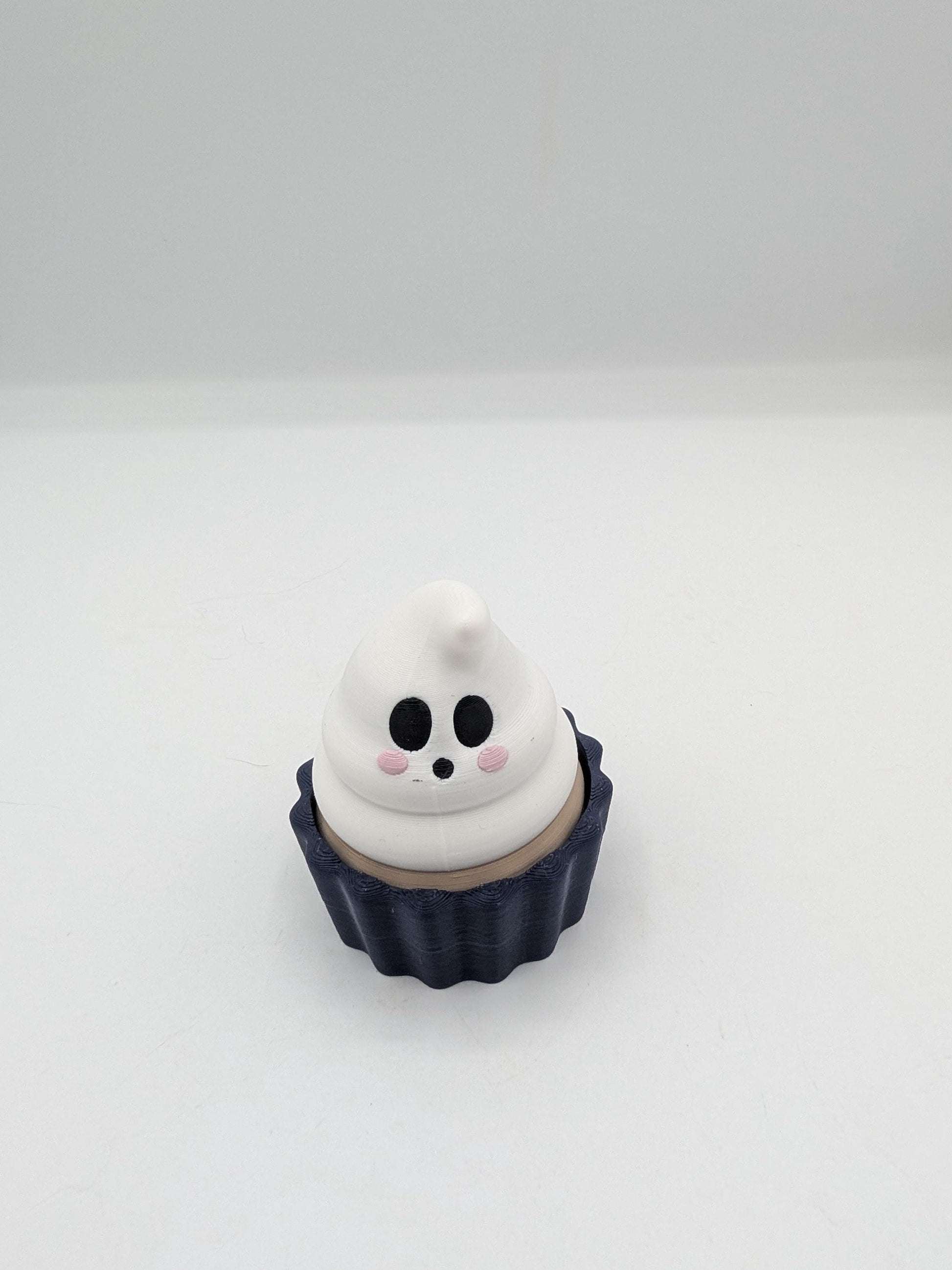 Ghost Halloween cupcake clicker fidget with white ghost frosting swirl face in a dark navy tin