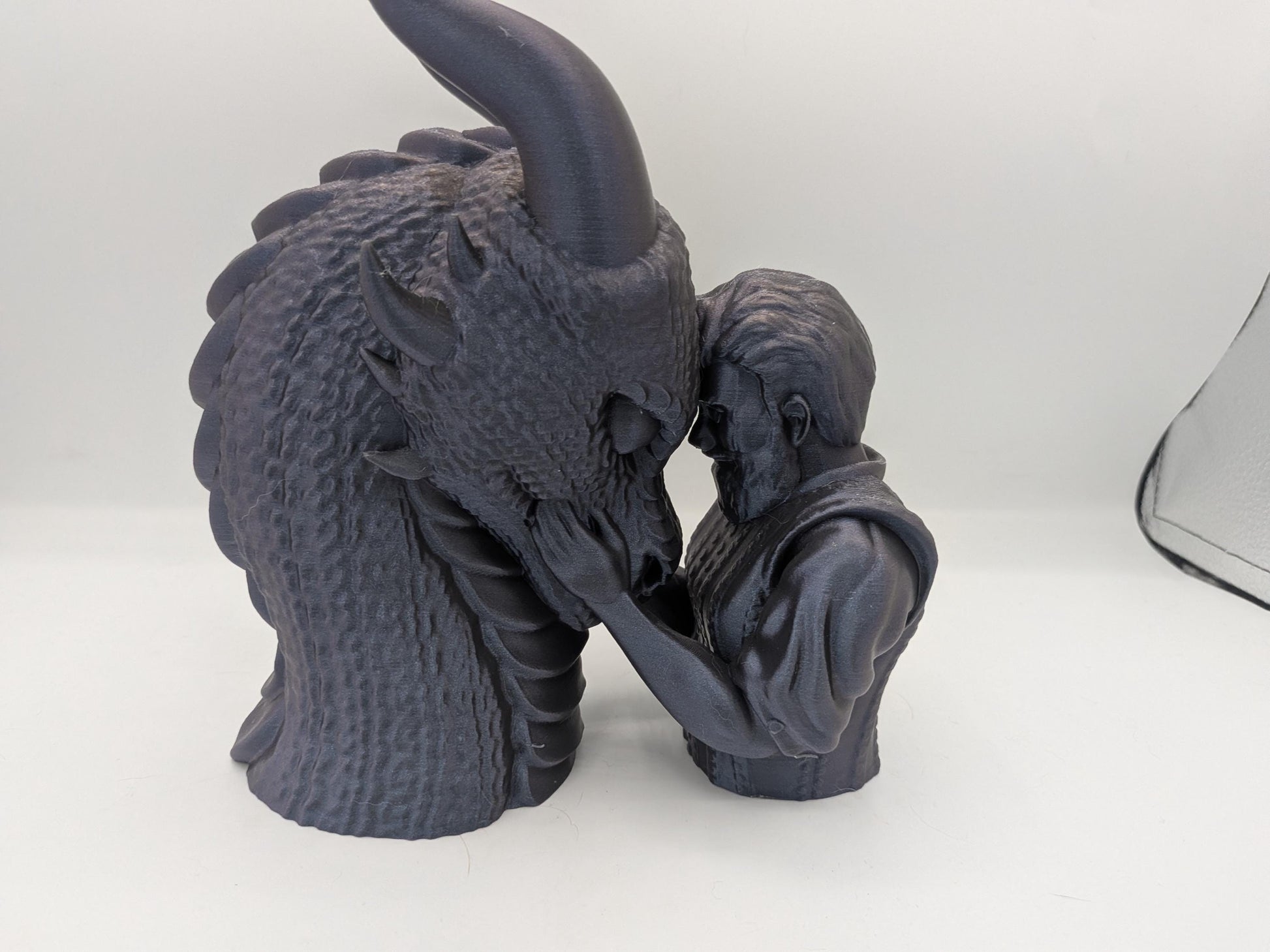 Close view of the male rider dragon bonding statue showing textured dragon scales and sculpted hair detail