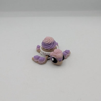 Cupcake turtle key clicker fidget facing forward with big eyes and pink purple frosting, 3D printed