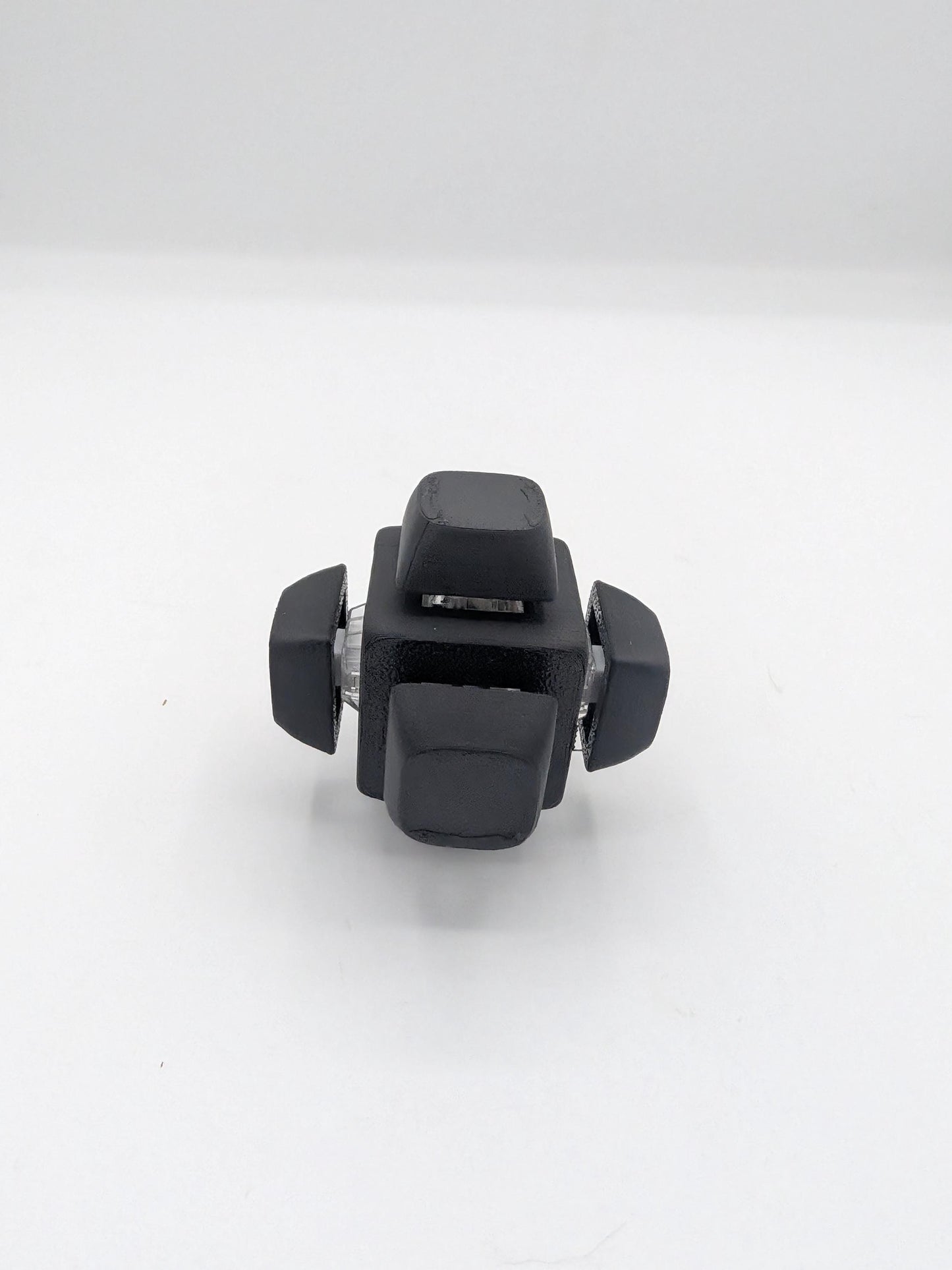 Angled view of black clicker cube key switch fidget showing keycaps and clear switch housings, 3D printed