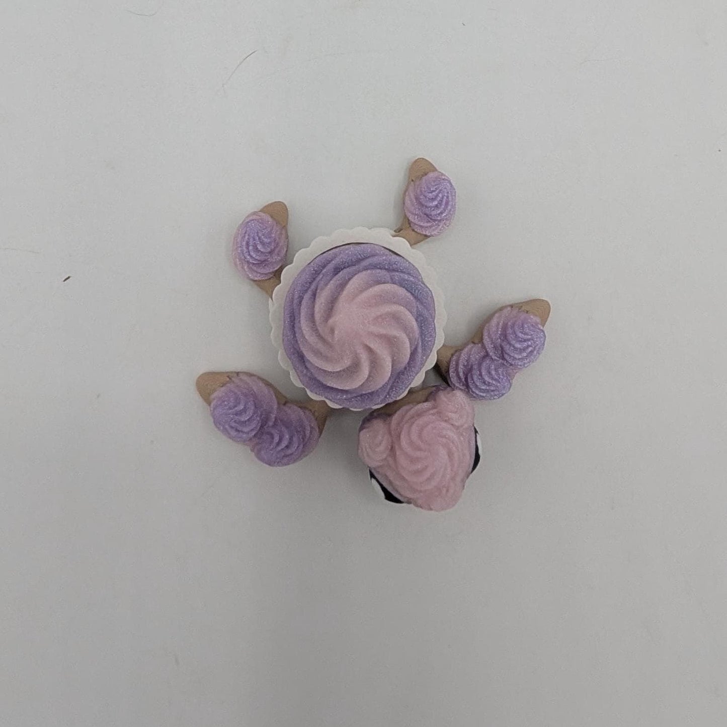 Top-down view of birthday cupcake turtle showing frosting swirl shell in white cupcake liner, 3D printed
