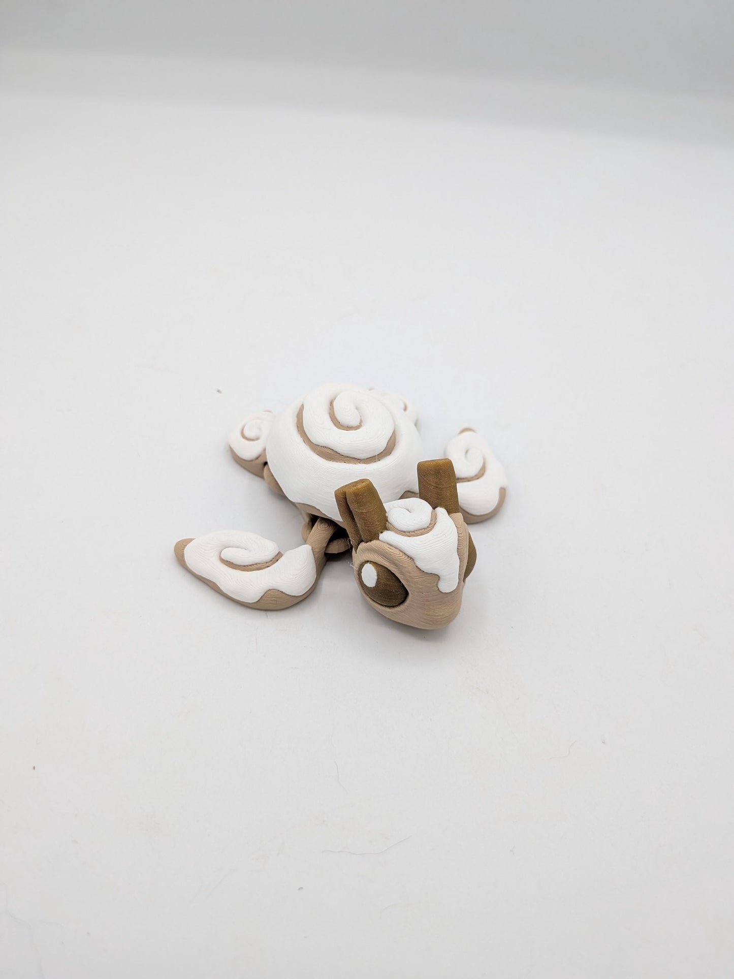 Cinnamon Bun Turtle flexi 3D print top view — swirled white icing shell and cinnamon roll flippers