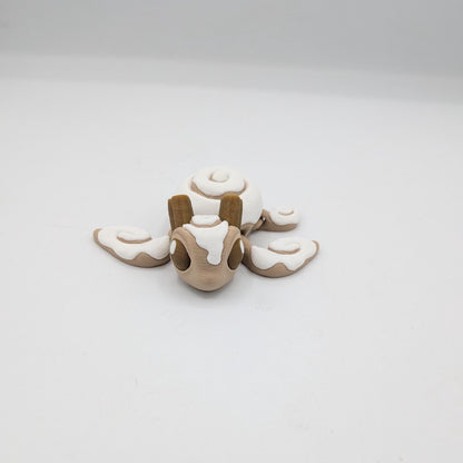 Cinnamon Bun Turtle flexi 3D print front view — frosted face with cinnamon sticks atop the head