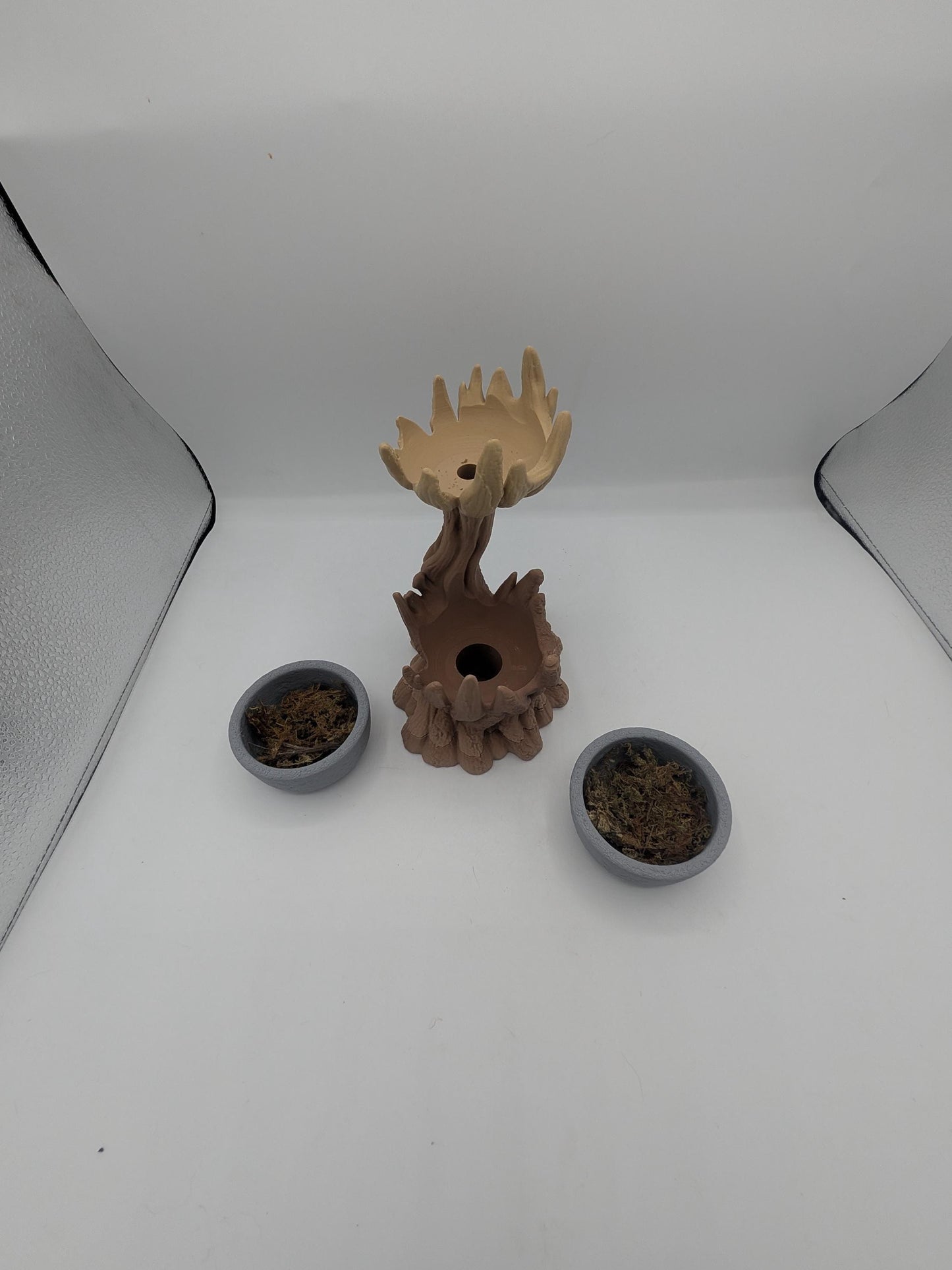 Spiral tree dual planter disassembled — the two removable gray bowls with faux moss beside the tree, showing the drainage opening in the base