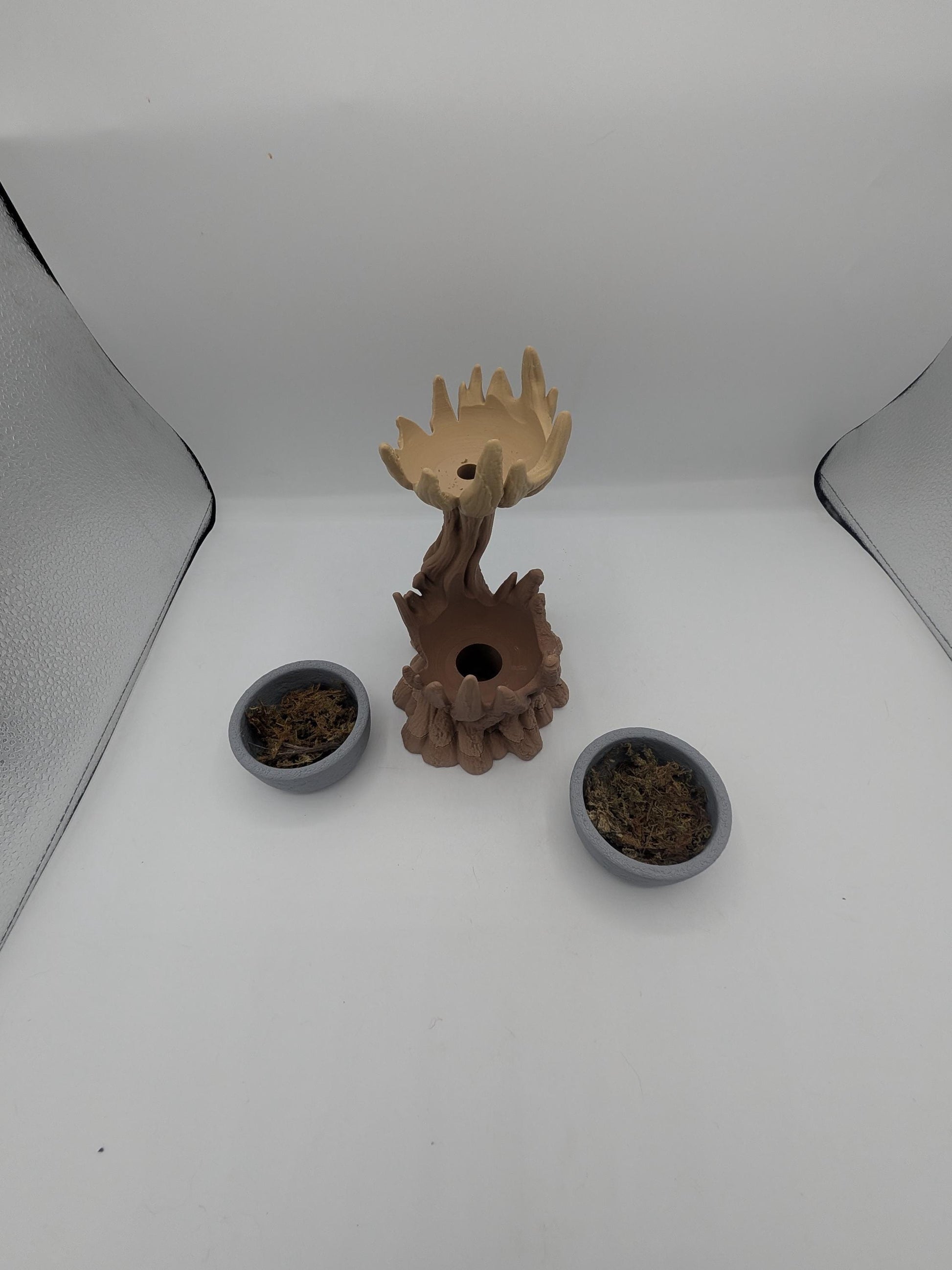 Spiral tree dual planter disassembled — the two removable gray bowls with faux moss beside the tree, showing the drainage opening in the base