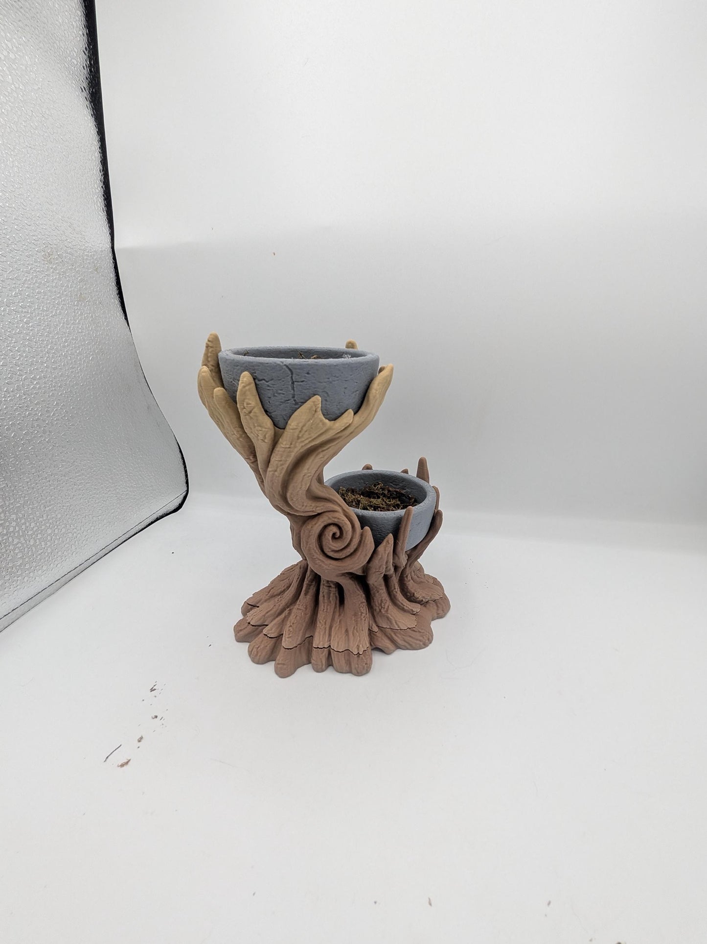 Side view of the spiral tree dual planter showing the swirled trunk detail and rooted base, upper bowl empty and lower bowl holding faux moss