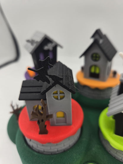 Close-up of the witch flying over the gray haunted house on the red base of the Halloween mini village 3D print