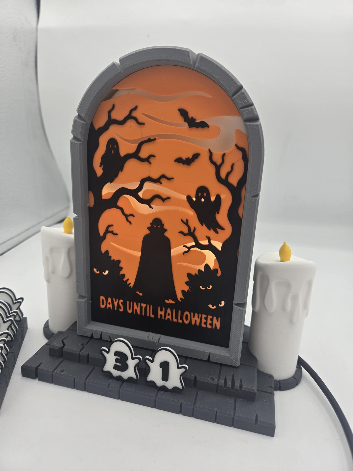 Vampire Halloween Countdown 3D print angled view — gray tombstone frame, layered orange scene, two dripping-wax style candles, and ghost number tiles reading 31