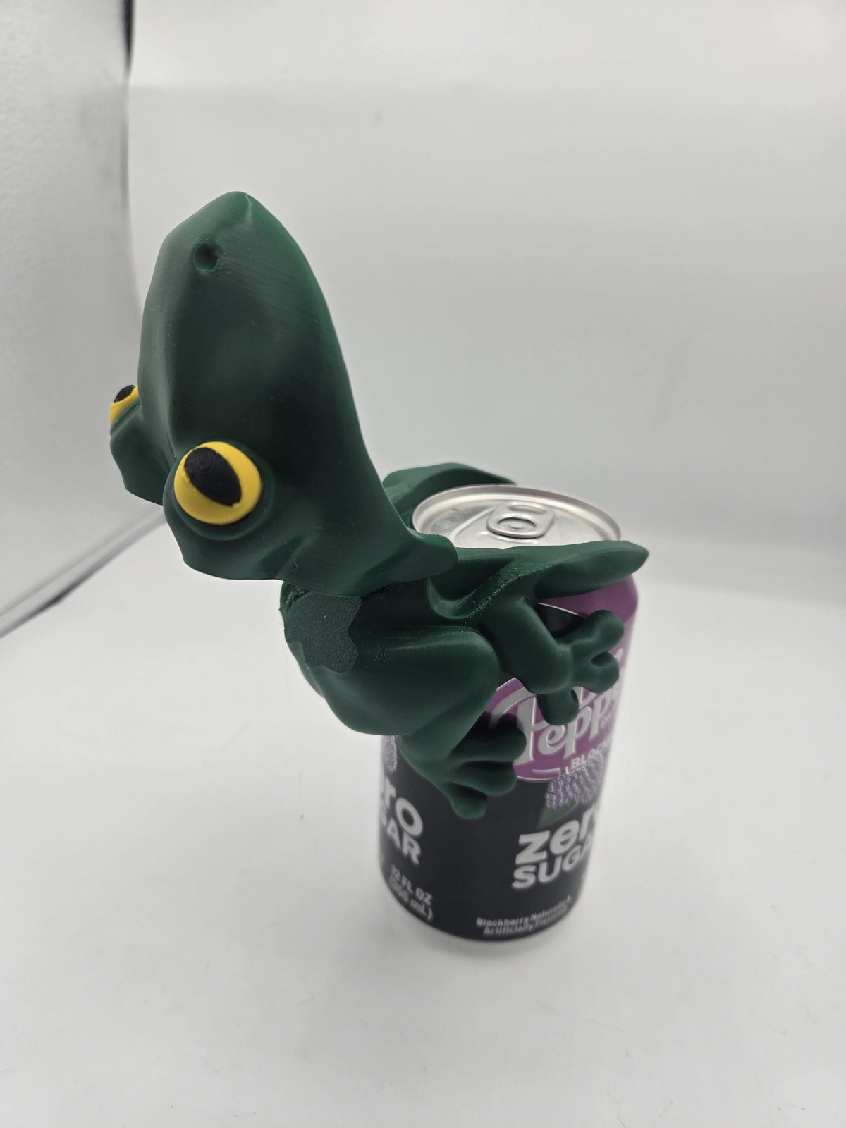 Frog Can Cover 3D print with the frog's mouth tilted open, exposing the can's drinking opening and pull tab while the legs stay clipped to the can