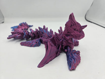 Ocean Sea Dragon flexi 3D print side view showing the flowing wing fins, front flipper legs, and jointed body segments in Blue-Purple Dual