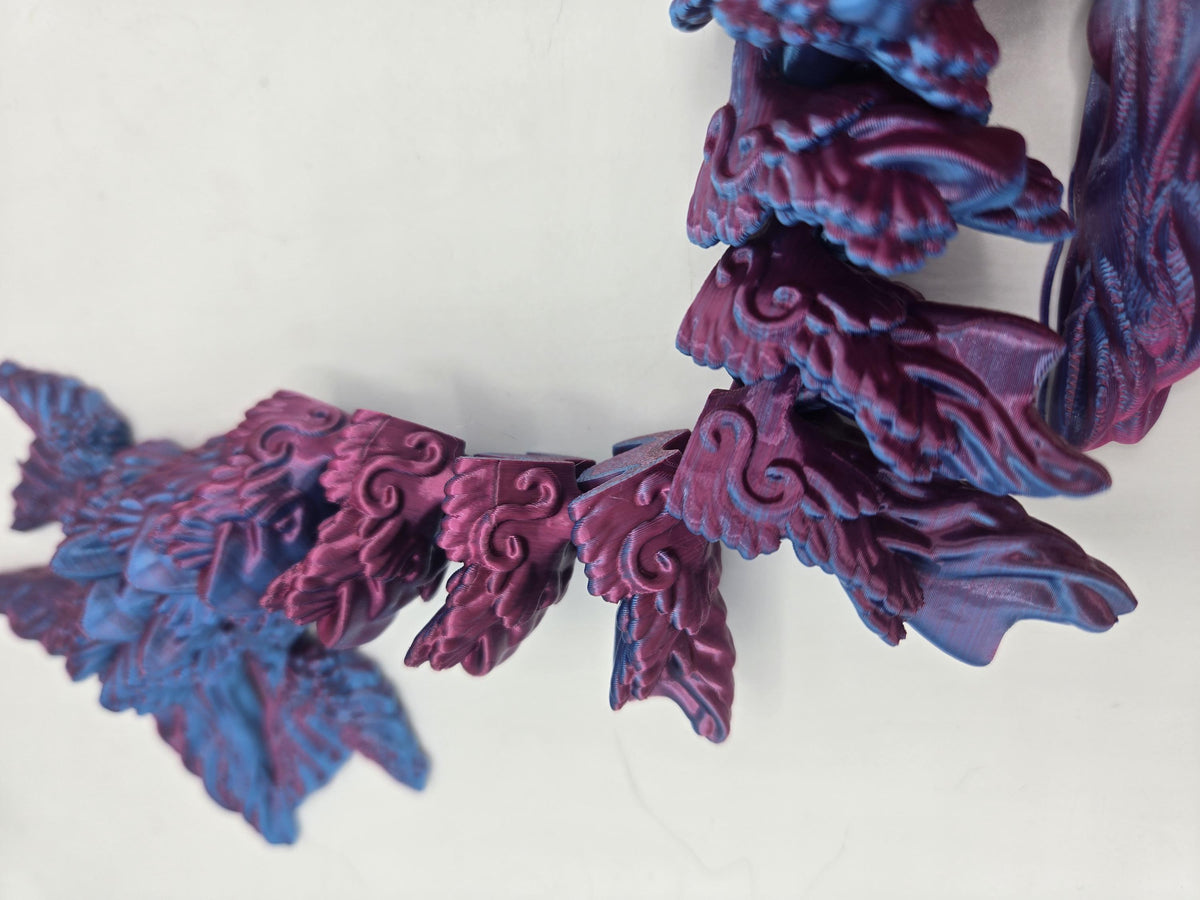 Ocean Sea Dragon flexi 3D print close-up detail of the interlocking articulated tail segments and swirl scale texture, Blue-Purple Dual